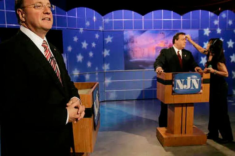 Former Bogota mayor Steve Lonegan (foreground) warms up before the debate while former U.S. attorney Christopher J. Christie, at the lectern, gets a bit of beautification for the TV cameras.
