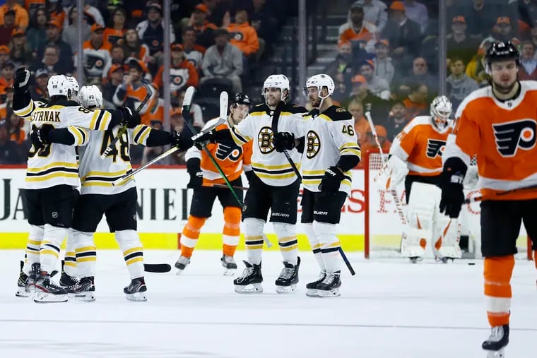 Boston Bruins' Matt Grzelcyk (48) celebrates with teammates after scoring a goal during the second period of an NHL hockey game against the Philadelphia Flyers on Tuesday in Philadelphia. Public health experts are raising alarms about such large public gatherings during the coronavirus pandemic (AP Photo/Matt Slocum)