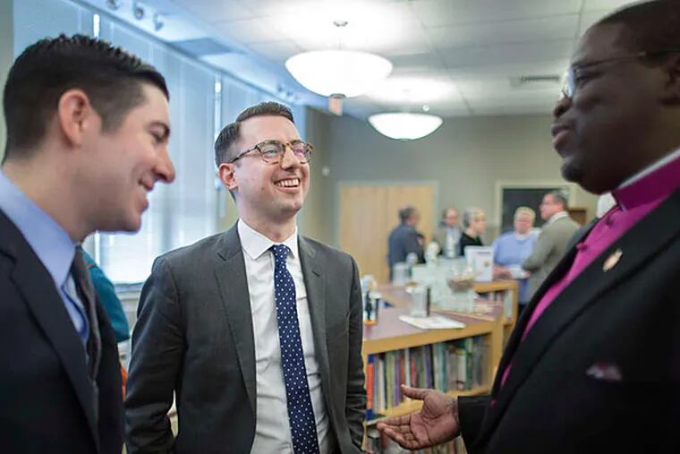 Thomas Rimbey Ogletree (center) and spouse Nicholas Haddad speak with Bishop Martin McLee following the announcement that Ogletree's father would not go to trial. (AP photo)