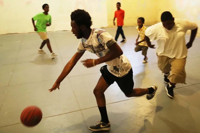 Assistant counselor Keyion Young, 16, plays basketball with other boys in the basement at the Able Center.