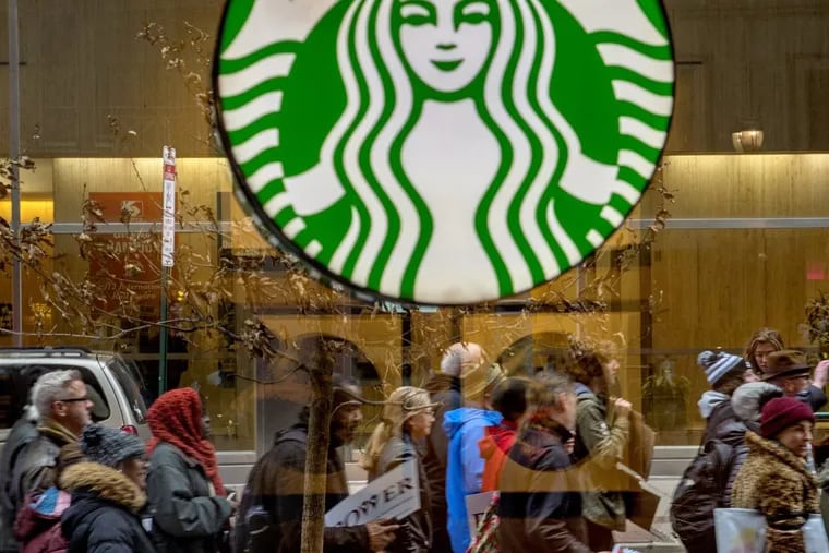 Protesters organized by the interfaith group POWER pass the Starbucks in the 1200 Block of Market Street, heading toward City Hall April 19, 2018, marching from Philadelphia police headquarters, rallying against the decision of officers to arrest two black men at a Center City Starbucks (not this one) last week. TOM GRALISH / Staff Photographer