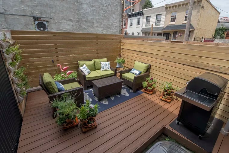 A deck with comfortable furnishings and greenery adds living space to this house in Fishtown.