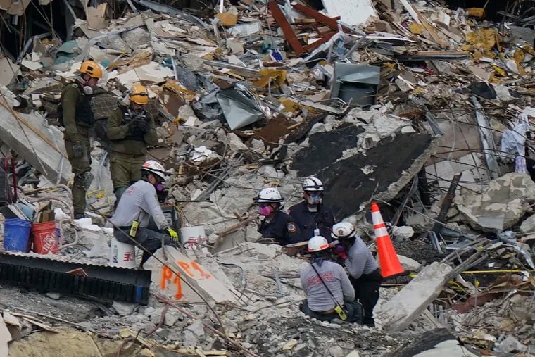 Members of an Israel team, top left, work alongside local search and rescue personnel atop the rubble at the Champlain Towers South condo building, where scores of people remain missing almost a week after it partially collapsed. The photo was taken June 30, 2021, in Surfside, Fla. (AP Photo/Lynne Sladky)