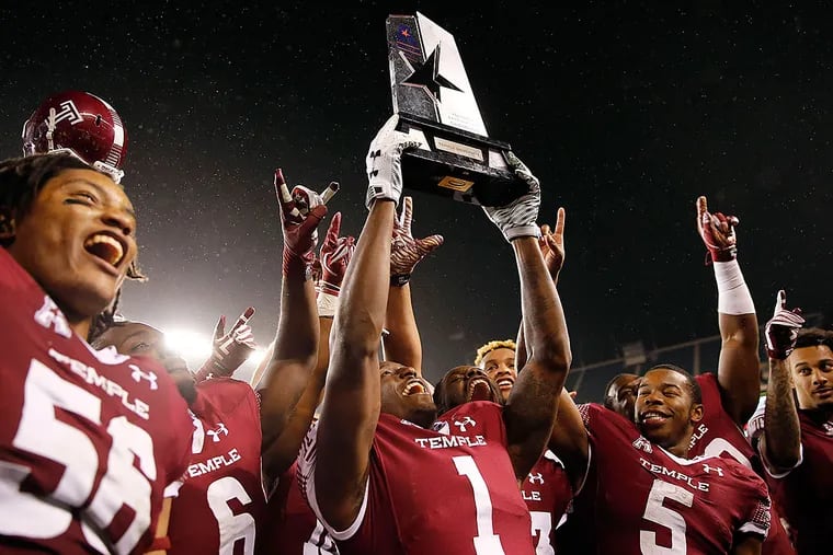 Temple's Tavon Young holds up the American East trophy.