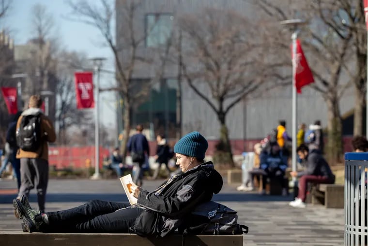 Kelly Christman, a sophomore at Temple University, reads a book on campus in warm weather in North Philadelphia. The university on Monday announced a new scholarship program to help students in need make it through graduation.
