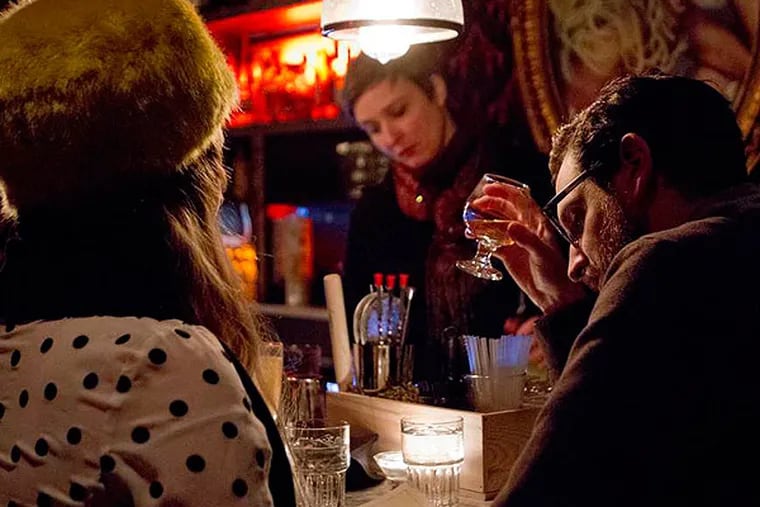 Jill Maxwell and Devon DeBlasio sit at the bar, facing bartender Phoebe Esmon at Emmanuelle, a cocktail spot in Northern Liberties.