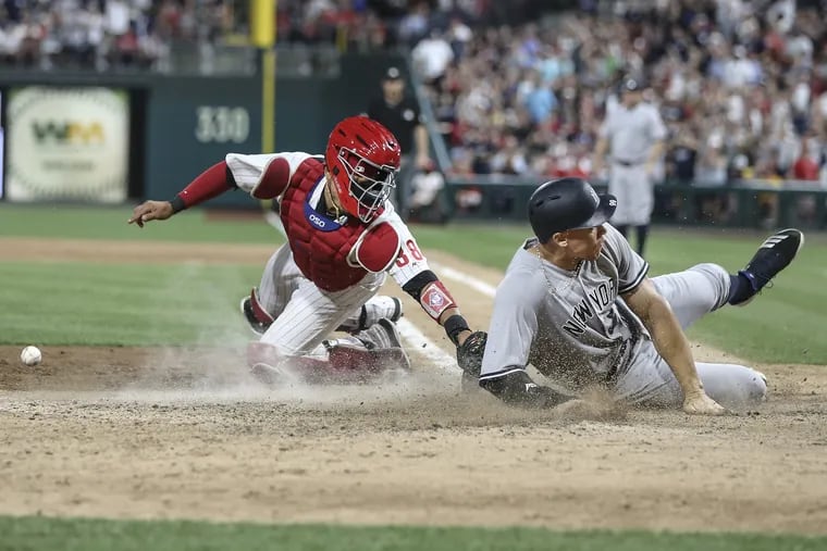 Phillies catcher Jorge Alfaro cannot hang onto the ball Aaron Judge slides past to score on a two-run single by Giancarlo Stanton during the eighth inning.