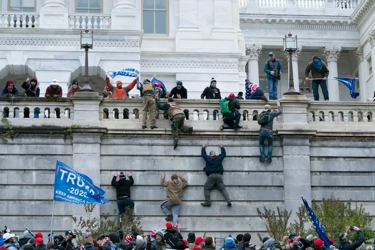 Violent insurrectionists loyal to then-President Donald Trump climbed the west wall of the the U.S. Capitol in Washington on Jan. 6.