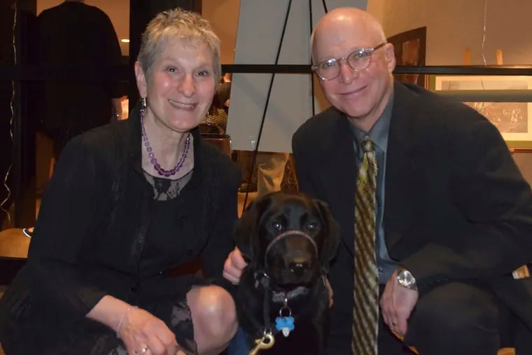 Puppy raisers Linda and Michael Dzuba with their dog-in-training Snugles at Canine Partners for Life's Art of the Bark fund-raising event at the Brandywine River Museum. MAGGIE HENRY CORCORAN