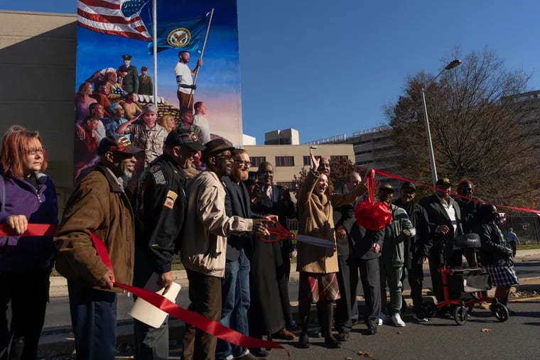 The ribbon is cut during a dedication ceremony for a new mural by James Burns at Philadelphia's Veterans Affairs Medical Center Nov. 8. Less than one in four veterans nationwide receive adequate mental health care.