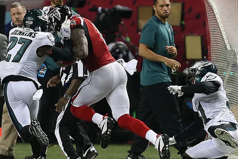 Malcolm Jenkins (left) tries to tackle the Falcons' Juilio Jones (center) as Byron Maxwell fails to make the play.