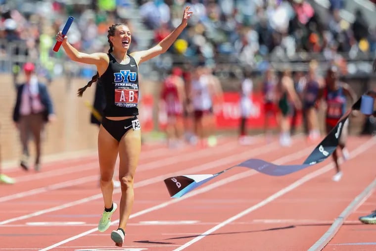 Courtney Wayment of BYU raises her arms in celebration after crossing the finishing line for the College Women's Distance Medley Championship of America at the 2022 Penn Relays at Franklin Field in Philadelphia on Friday, April 29, 2022.