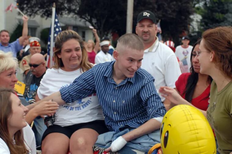 Marine Cpl. Raymond D. Hennagir is greeted by (from left) his aunt Donna English; cousins Sherri English, Mia English and Nadia Pinzuti; and fiancee Sherri Baskerville as he returns to Deptford in a Mustang convertible. More than a thousand people lined the roads to Hennagir&#0039;s house Friday to welcome him home for the first time from the Walter Reed Army Medical Center, three months after he was wounded. Rehab will keep him at Walter Reed for the next year.