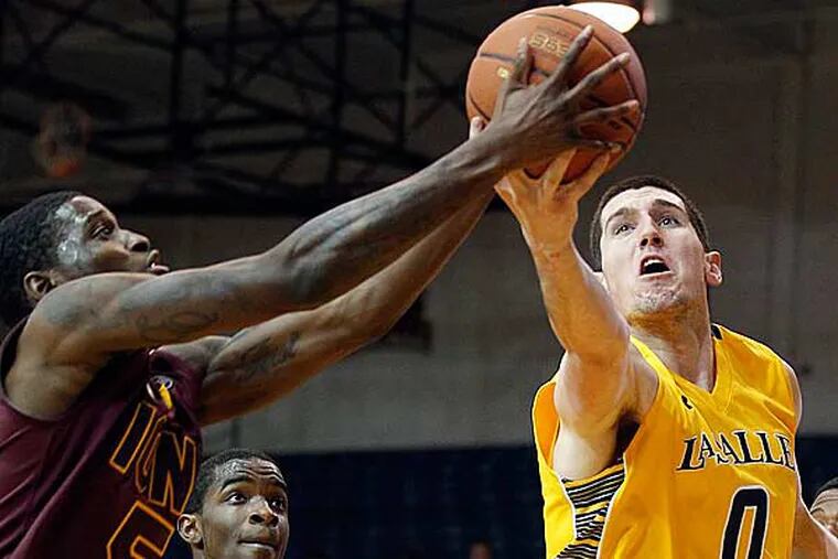 La Salle's Steve Zack (right) goes after the basketball against Iona's A.J. English (left) and Sean Armand in the first half on Thursday, December 20, 2012. (Yong Kim/Staff Photographer)