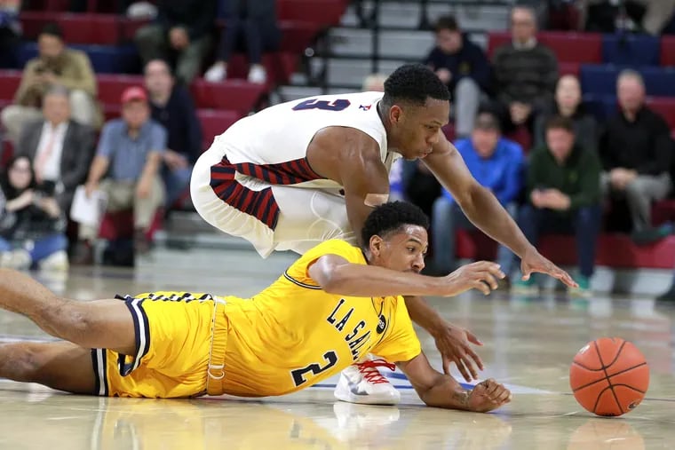 Jordan Dingle, top, of Penn and Scott Spencer of La Salle go after a loose ball during the 2nd half on Nov. 13, 2019.  