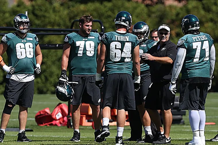 Eagles offensive linemen gather during practice. (David Maialetti/Staff Photographer)
