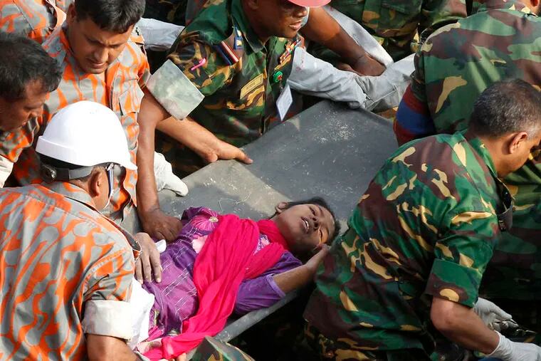 Rescuers carry a survivor from the rubble of a building in Bangladesh. The woman was said to be in good condition.