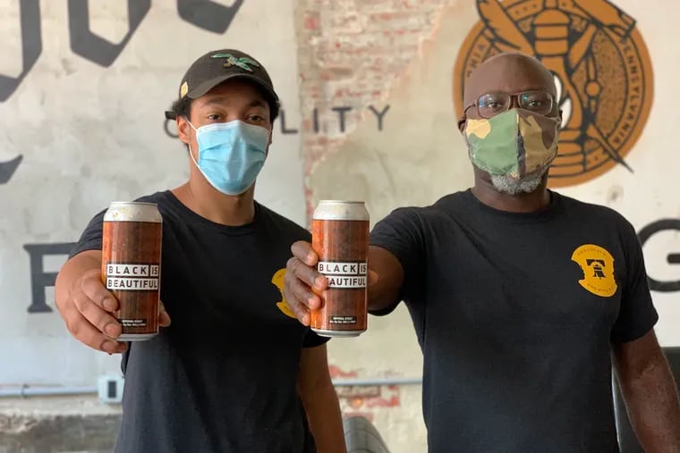 Brothers Richard and Mengistu Koilor, the founders of Two Locals Brewing Co., holding cans of Black is Beautiful beer, produced at Love City Brewery in Philadelphia.