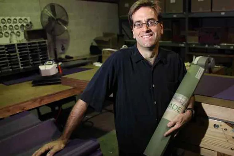 Dean Jerrehian, president of JadeYoga, with an eco-friendly yoga mat made at the firm's facility in Conshohocken.