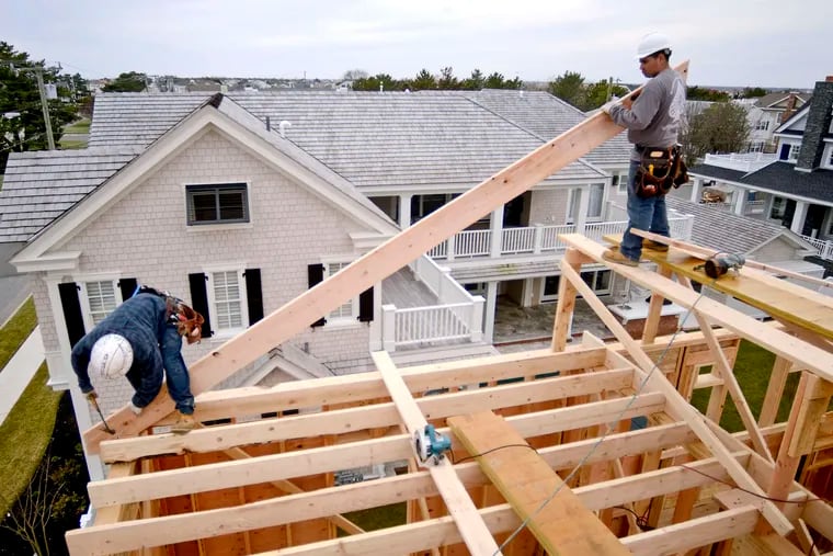Workers help build a home in Stone Harbor. Construction workers are in short supply and competition is mounting among builders in 33 major markets as the number of new-home communities increases.