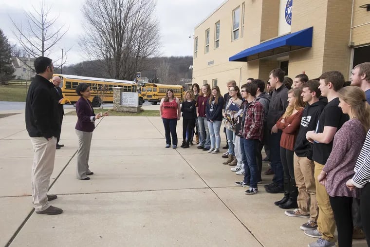 Outside Downingtown West High School, assistant principal Ilana Shipe and teacher Dan Soler brief students on their trip to the presidential inauguration in Washington.
