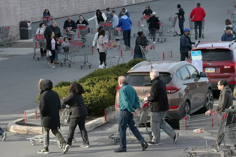 Hundreds of shoppers wind their carts through several rows of parking spaces as they line up to enter BJ's Wholesale Club in Springfield, Pa., when it opened at 9 a.m. on Saturday, March 14, 2020. Customers were stocking up on food and supplies after Gov. Tom Wolf asked non-essential businesses in Delaware County to close due to the coronavirus pandemic.