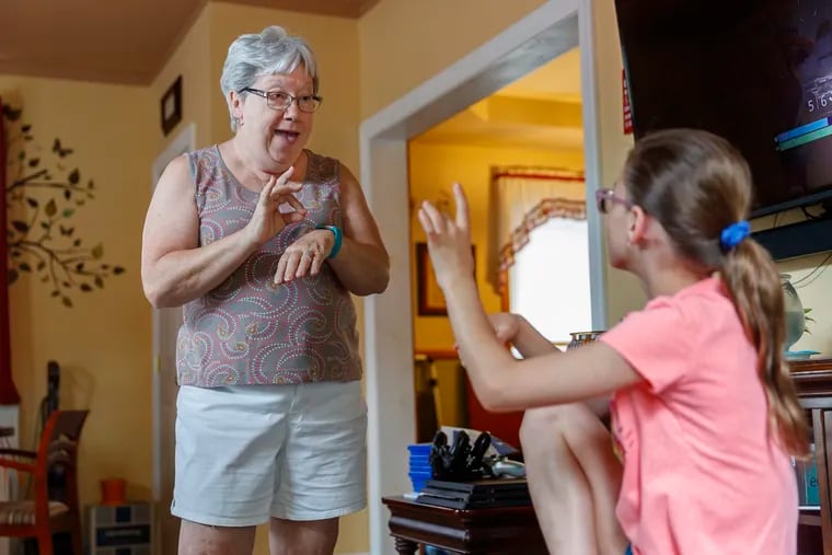 Pat Pomroy, left, has a sign language conversation with her granddaughter, Rachael, 9, as they prepare to have a pool party at their Croydon, PA home on July 15, 2018.