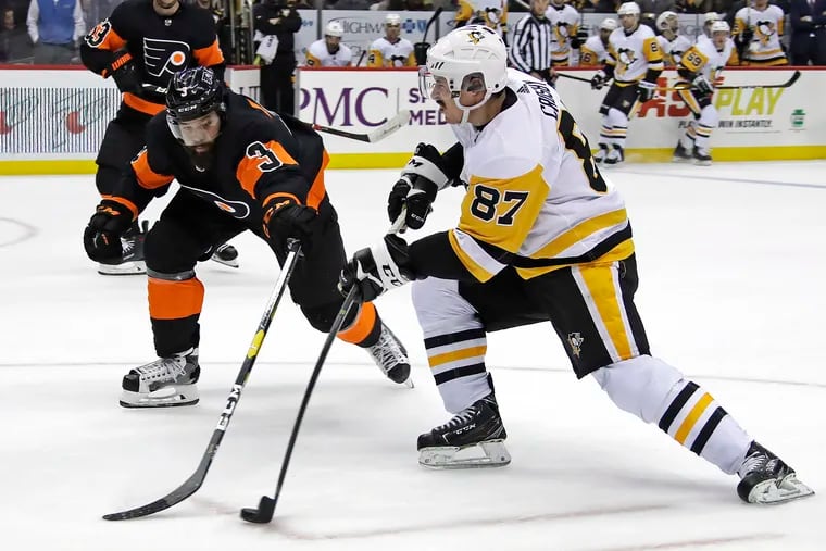 Sidney Crosby (87) has a shot deflected by Philadelphia Flyers' Radko Gudas (3) during the second period of an NHL hockey game in Pittsburgh, Saturday, Dec. 1, 2018.