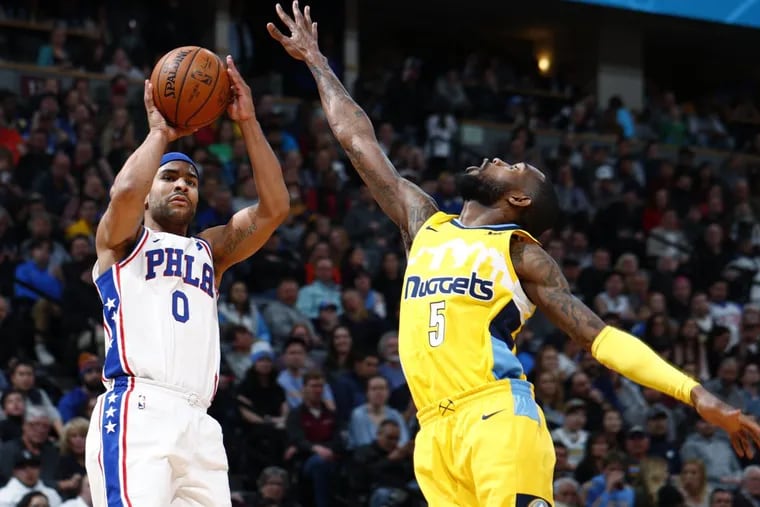 Sixers’ Jerryd Bayless, left, goes up for a three-point basket over Denver Nuggets guard Will Barton in the second half.