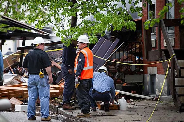 Philadelphia fire, police and a PGW crew work along the 2300 block of Naudain, investigating and cleaning up after an early morning fire and explosion on Thursday morning May 1, 2014.