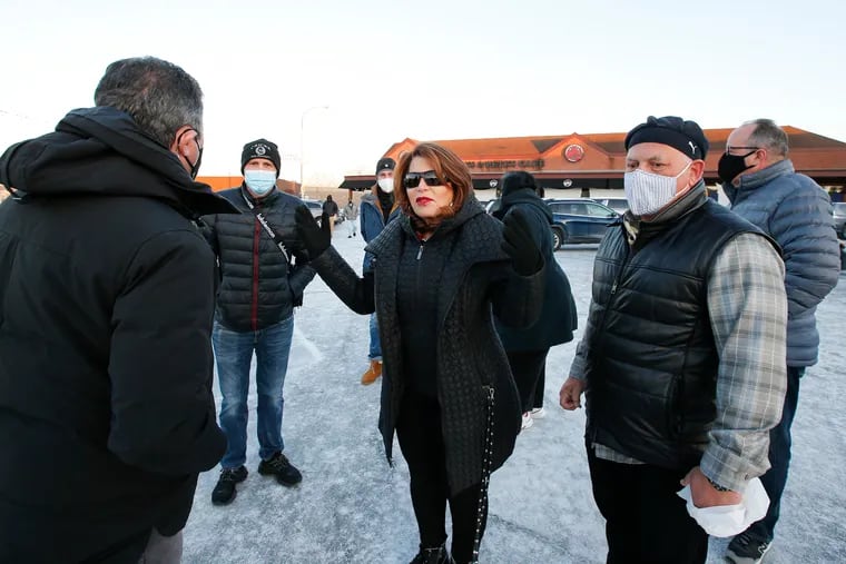 Barbara Capozzi (center), president of the Packer Park Civic Association, talks to members at the Packer Park Shopping Center parking lot near the Chickie's & Pete's in South Philadelphia on Monday.