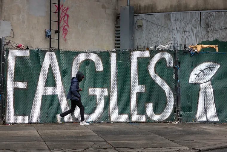 Someone walks past an Eagles sign in Kensington.