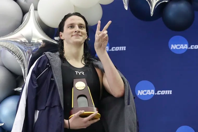 Penn swimmer Lia Thomas poses with her trophy after finishing first in the 500-yard freestyle race during the NCAA women's swimming and diving championships in Atlanta.
