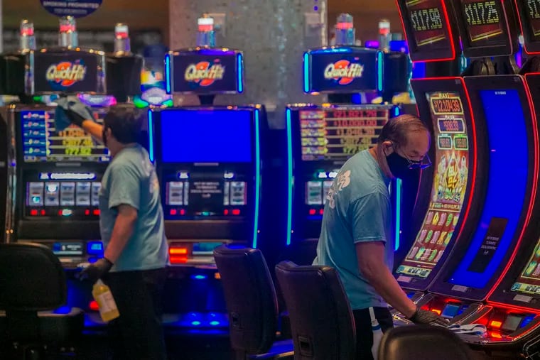 Members of the Clean Team wipe down electronic gambling machines at Ocean Casino in Atlantic City, NJ, in 2020.