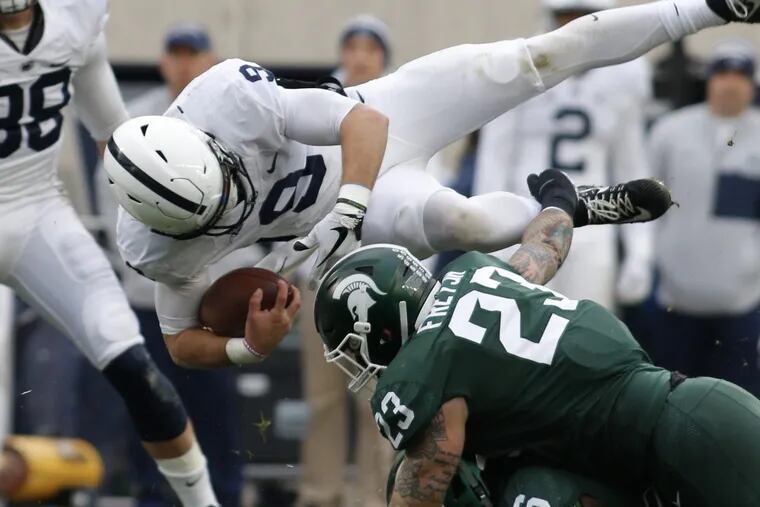 Penn State quarterback Trace McSorley, top, is upended by Michigan State’s Chris Frey (23) on Saturday.