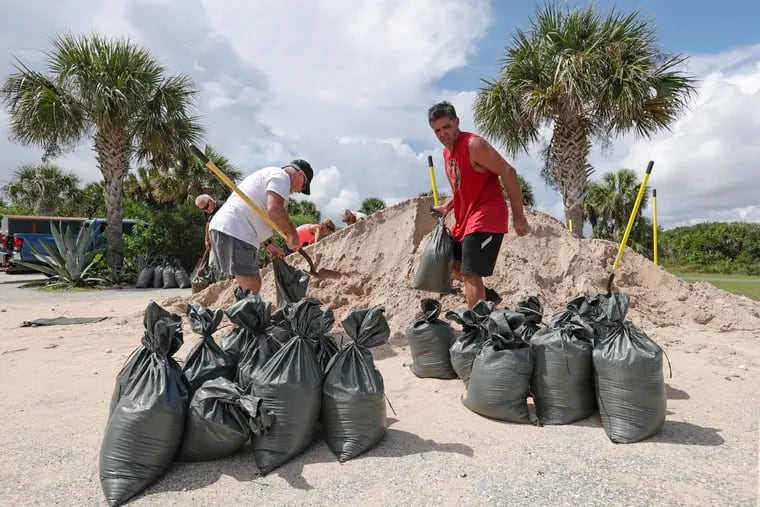 Residents of Flagler Beach, Fla., fill sandbags Friday, Aug. 30, 2019, to help protect their homes in preparation for Hurricane Dorian Friday, Aug. 30, 2019.