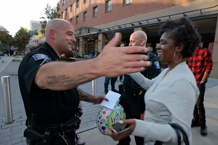 Former Temple Police Officer Justin Busam (left) greets Kamille Young on the Temple campus in Philadelphia on Wednesday. Busam helped to deliver Kamille’s baby, Aamanee, in a Cadillac on North Broad Street in 2013.
