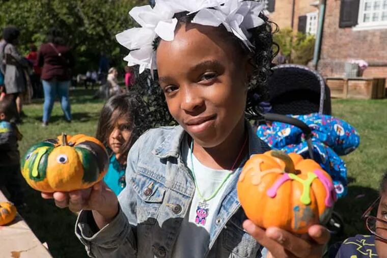 The venerable Wofford Mansion in Fairmount Park holds its annual Apple Festival featuring games,crafts and of course apples. Here, 9 year old Iniya Saunders-Thompson shows off her decorated pumpkins. (ED HILLE / Staff Photographer)