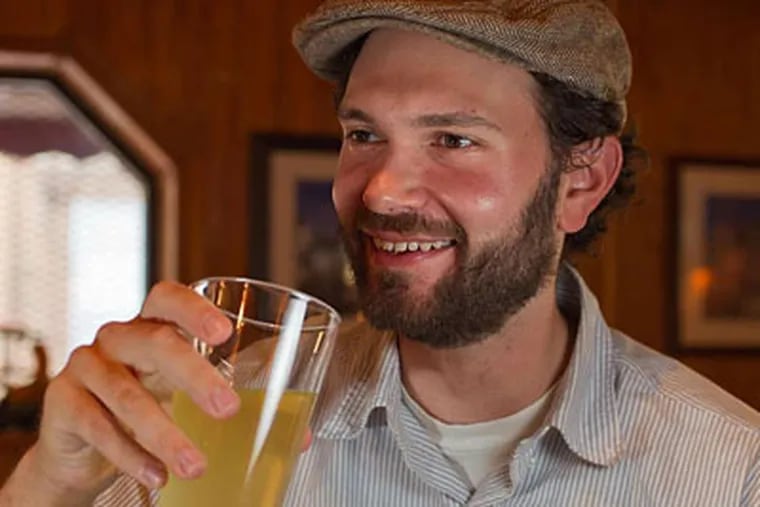 Jonathan Gradman sips his Revolution Cider at Watkins Drinkery. Gradman, the brewmaster, says the cider has &quot;the complexity of a craft beer but with the aroma and taste of apples.&quot;