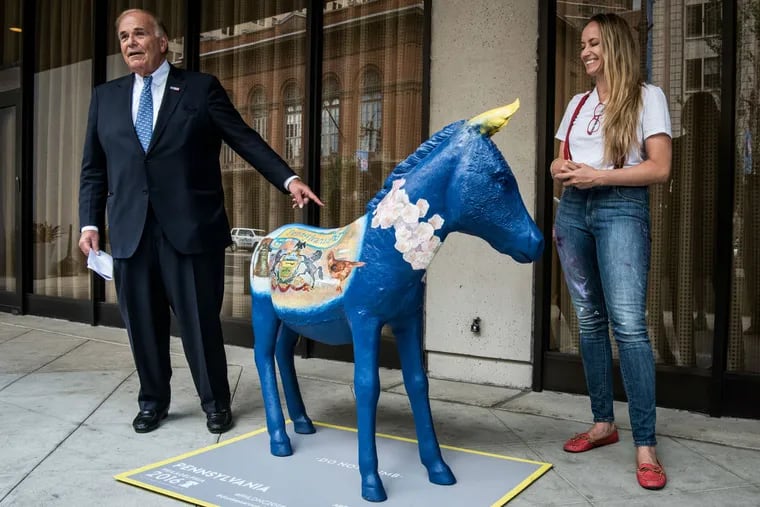 Former Pennsylvania Gov. Ed Rendell stands with Art Jawn CEO Caryn Kunkle next to a fiberglass donkey representing the state outside the DoubleTree Hotel on South Broad Street in Philadelphia.