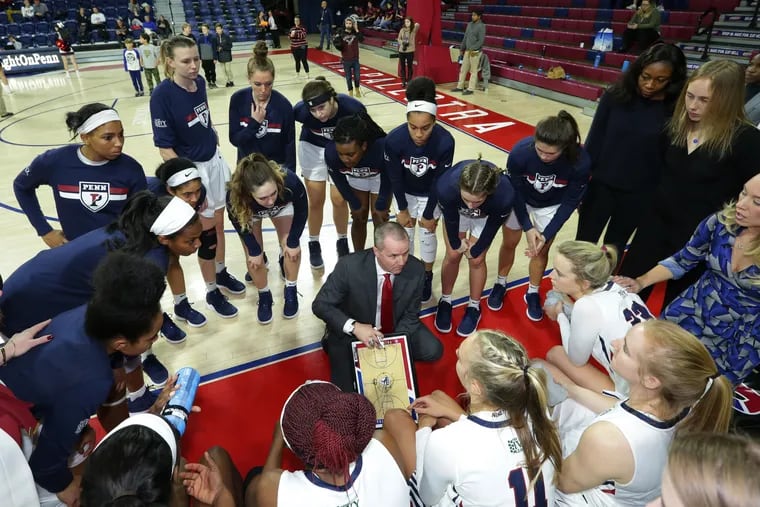 Penn players gather around coach Mike McLaughlin during a women's basketball game against La Salle.