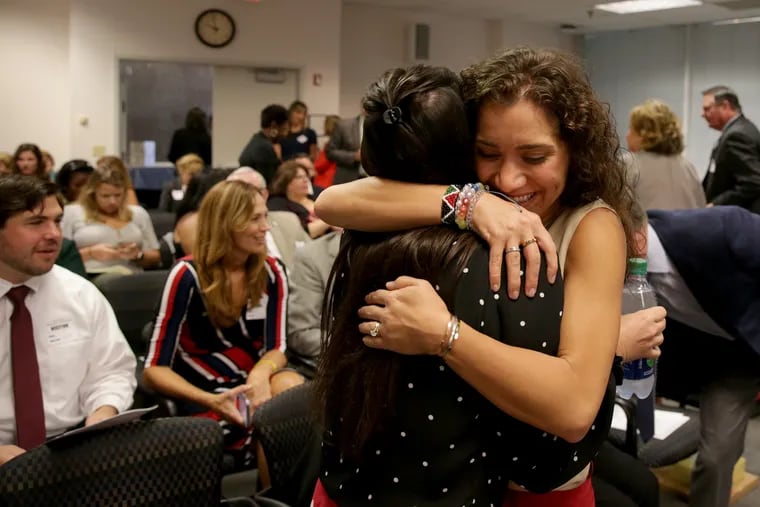 Kimberly Dickstein Hughes, right, gets a hug from her sister, Katelynn Brotz, left, before the official announcement of the New Jersey Teacher of the Year at the State Board of Education in Trenton on Oct. 2. Kimberly teaches English at Haddonfield Memorial High School