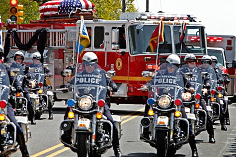Philadelphia Highway Patrol officers lead Engine 7, which bore the casket of Firefighter Daniel Sweeney from St. Cecilia Roman Catholic Church on Rhawn Street. ALEJANDRO A. ALVAREZ / Staff Photographer
