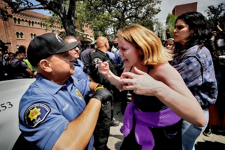 A University of Southern California protester, right, confronts a University Public Safety officer at the campus' Alumni Park during a pro-Palestinian occupation.