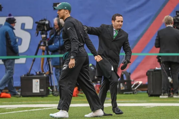 Eagle' general manager Howie Roseman (right) gives Eagles starting quarterback Nick Foles a good luck pat on the back during warmups at MetLife Stadium prior to Sunday's game against the Giants.