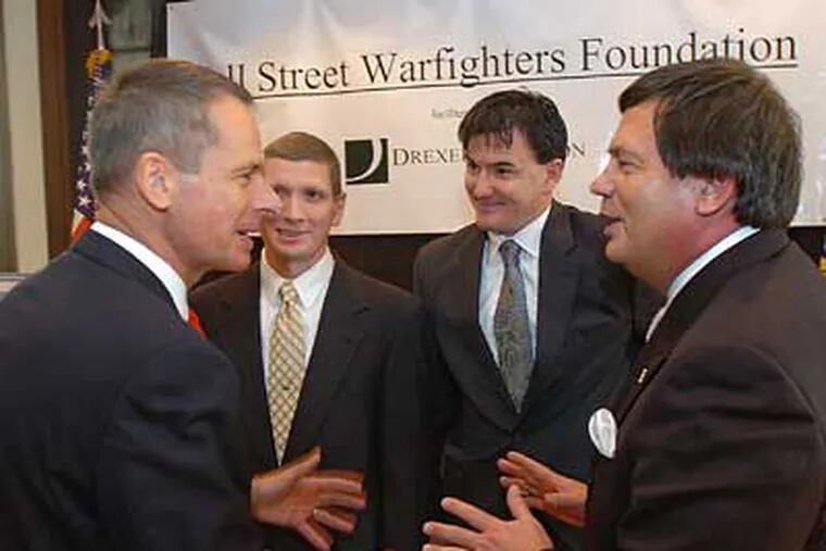 Retired Marine General Peter Pace (left) and Larry Doll (right), CEO of Drexel Hamilton, a Philadelphia-based investment house,  talk with U.S. Army Master Sgt. George Holmes (second from left) and Marine Staff Sgt. John Jones during an event for the Wall Street Warfighters Foundation. (Clem Murray / Staff Photographer)