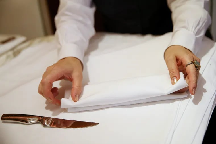 A server folds napkins while preparing for dinner service at Barclay Prime in Philadelphia's Rittenhouse Square. Coronavirus has caused a financial crisis for restaurant workers who depend on tips.