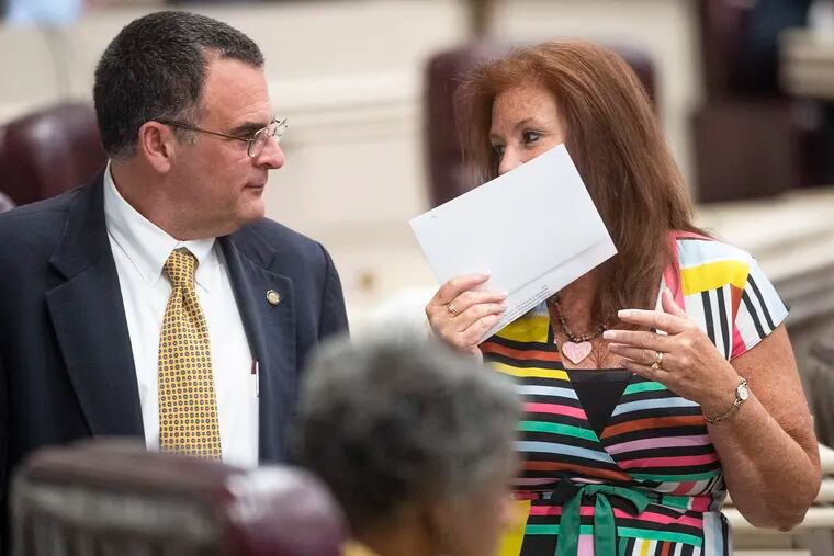 Rep. Terri Collins (right) chats with Rep. Chris Pringle on the house floor at the Alabama Statehouse in Montgomery, Ala., on Tuesday, May 14, 2019. Collins is the sponsor of the state's antiabortion bill. (Mickey Welsh / Montgomery Advertiser via AP)