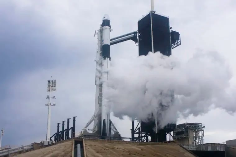 In this Wednesday image from video made available by SpaceX, liquid oxygen vents off the Falcon 9 rocket as NASA astronauts Bob Behnken and Doug Hurley in the Crew Dragon capsule prepare for launch from the Kennedy Space Center in Cape Canaveral, Fla., moments before the mission was aborted because of weather problems.
