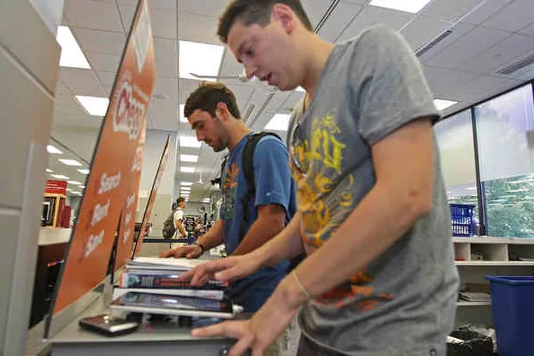 At the Villanova University bookstore, seniors Gregory Dyer (left) and Paul Passariello use iPads to rent books from Chegg.com, which is working with the store to offer 620 titles for rental this year.